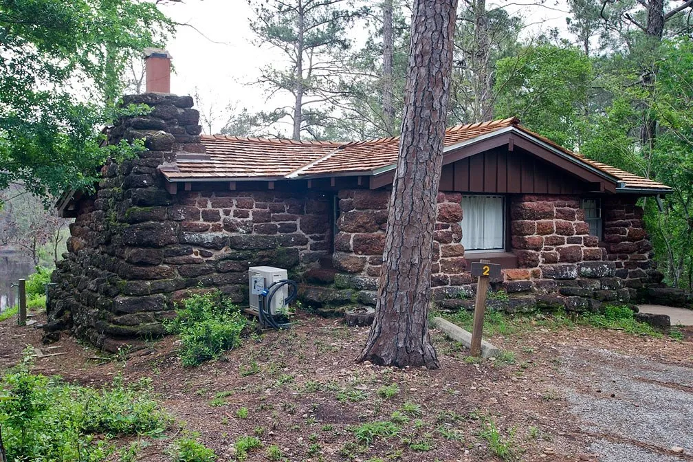 Historic cabin with a stone chimney at Bastrop State Park