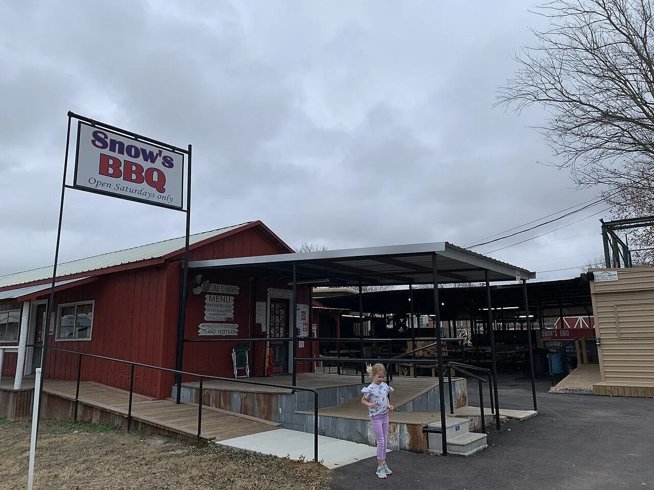 The red exterior and open-air serving area at Snow's BBQ in Lexington, Texas