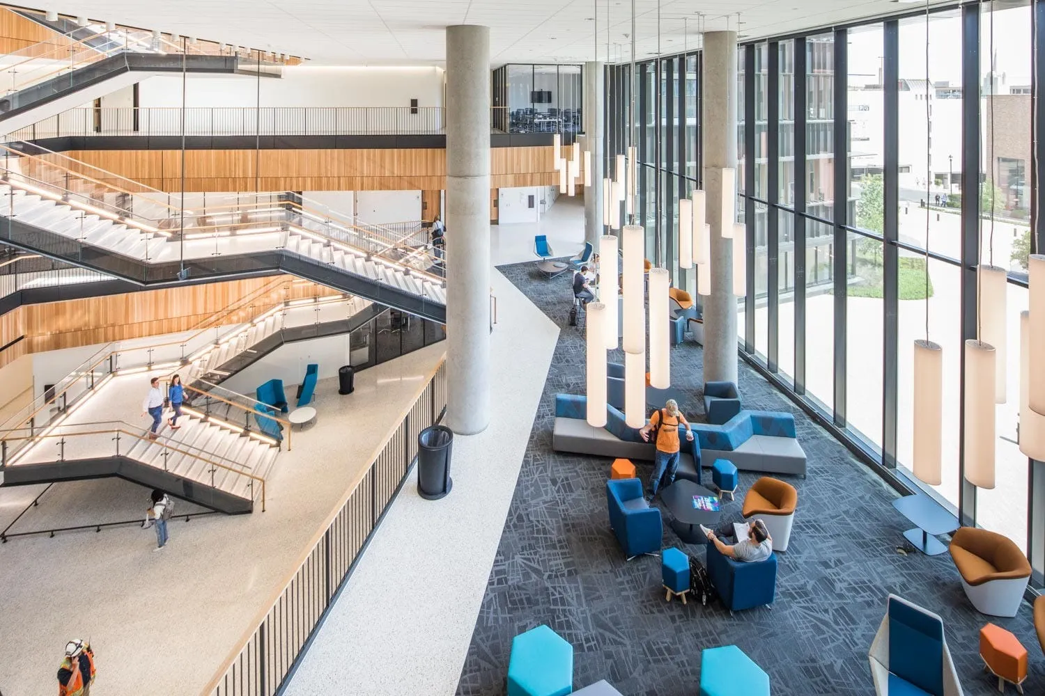 The bright multistory atrium inside Robert B. Rowling Hall with stairs, study areas and students