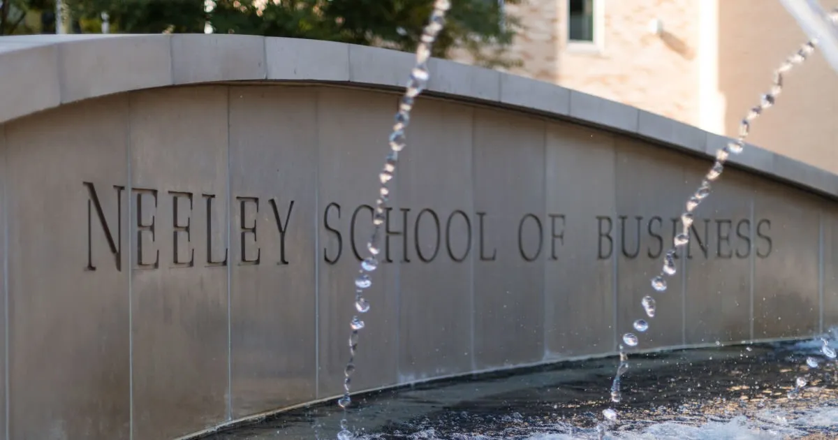 The Neeley School of Business name carved into a curved stone fountain wall at TCU