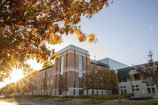 The brick and glass Paul L. Foster Campus for Business and Innovation in autumn sunlight