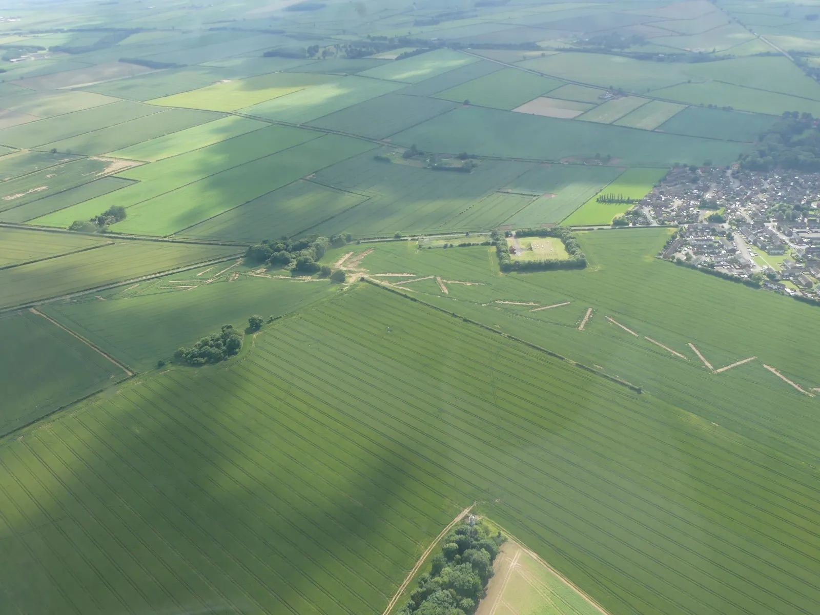 An aerial view of survey and investigation work crossing farm fields along a planned pipeline route