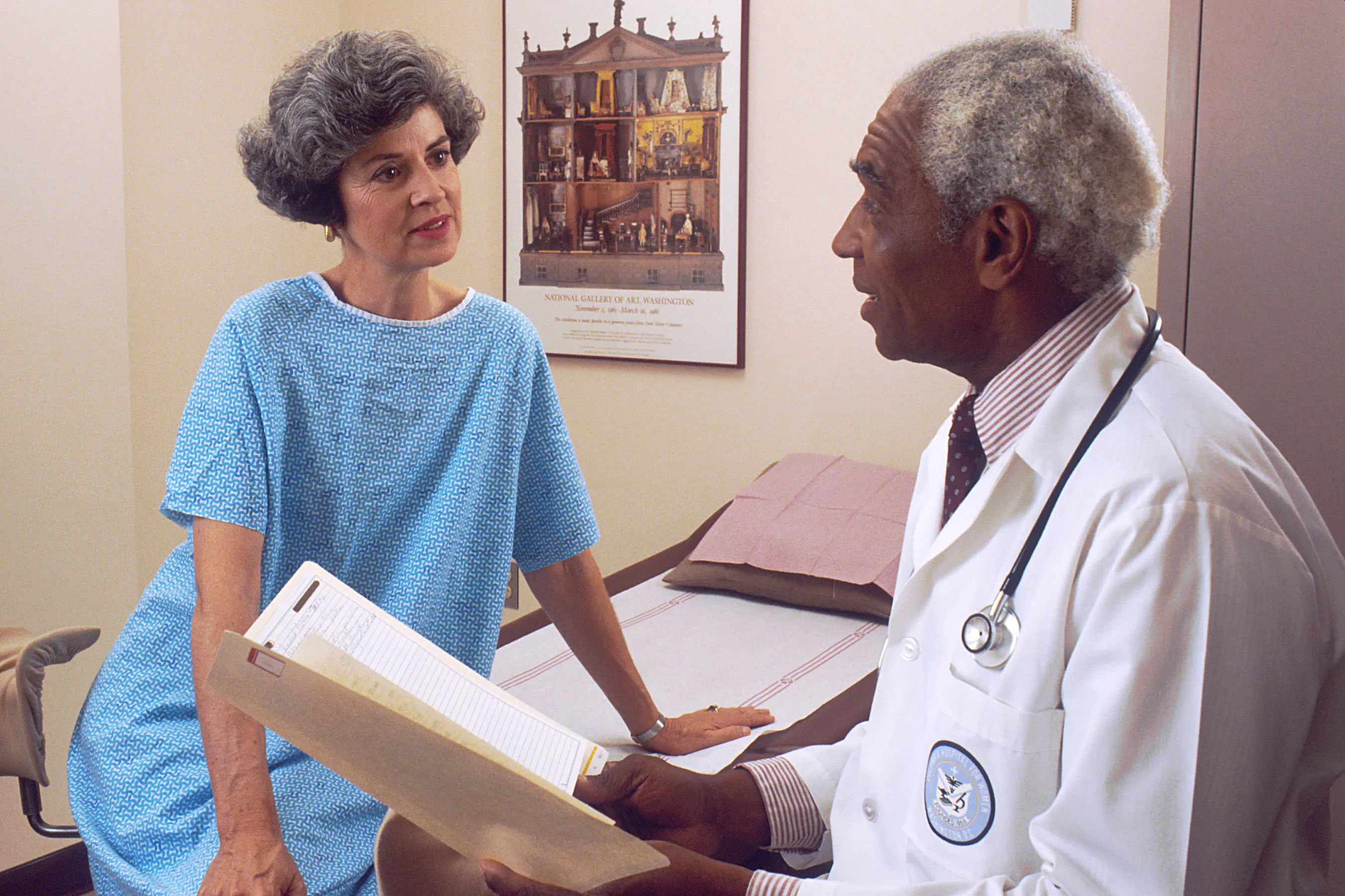 A doctor talks with a patient in an examination room