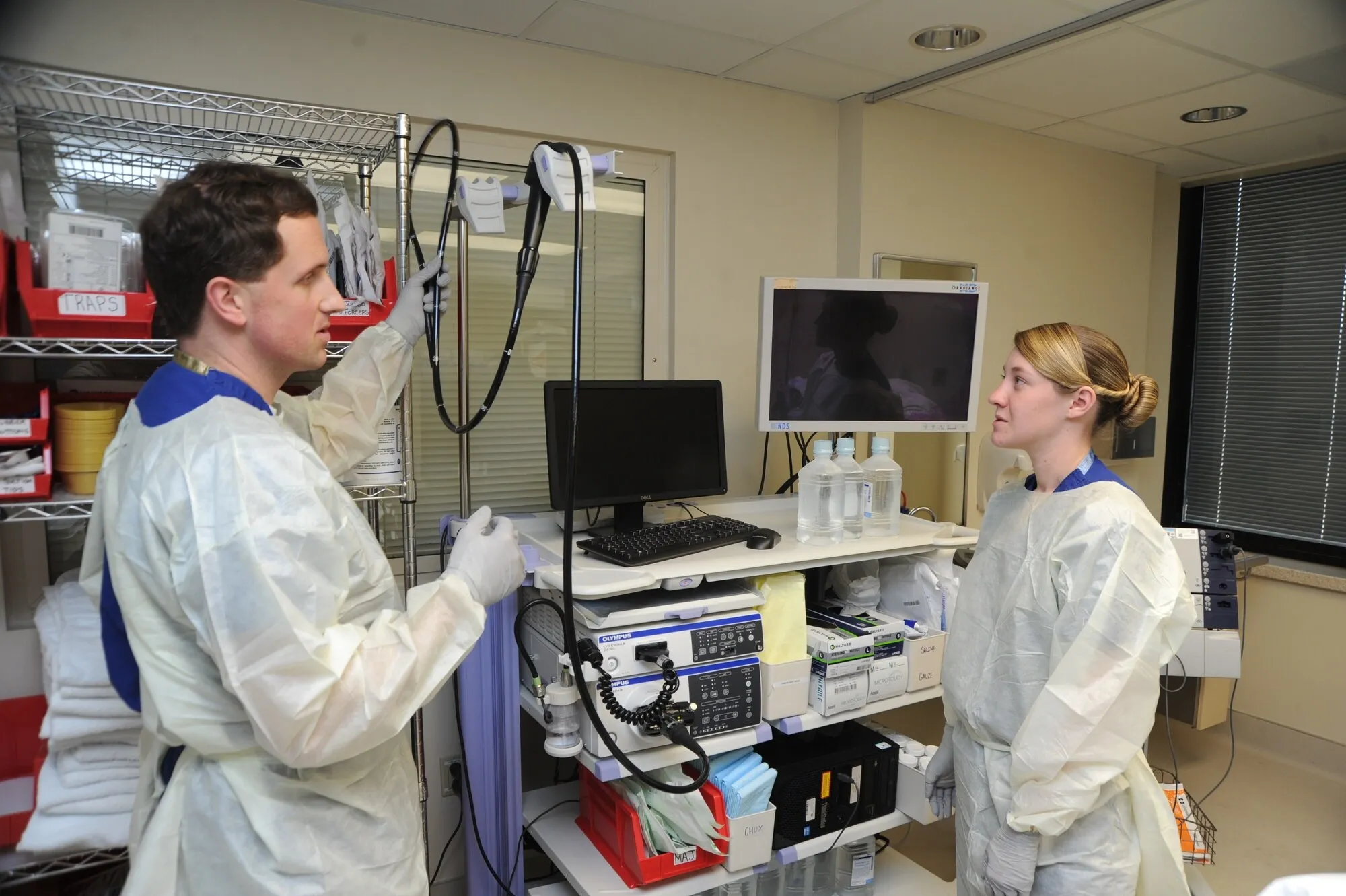 A gastroenterologist and corpsman prepare colonoscopes in an endoscopy unit