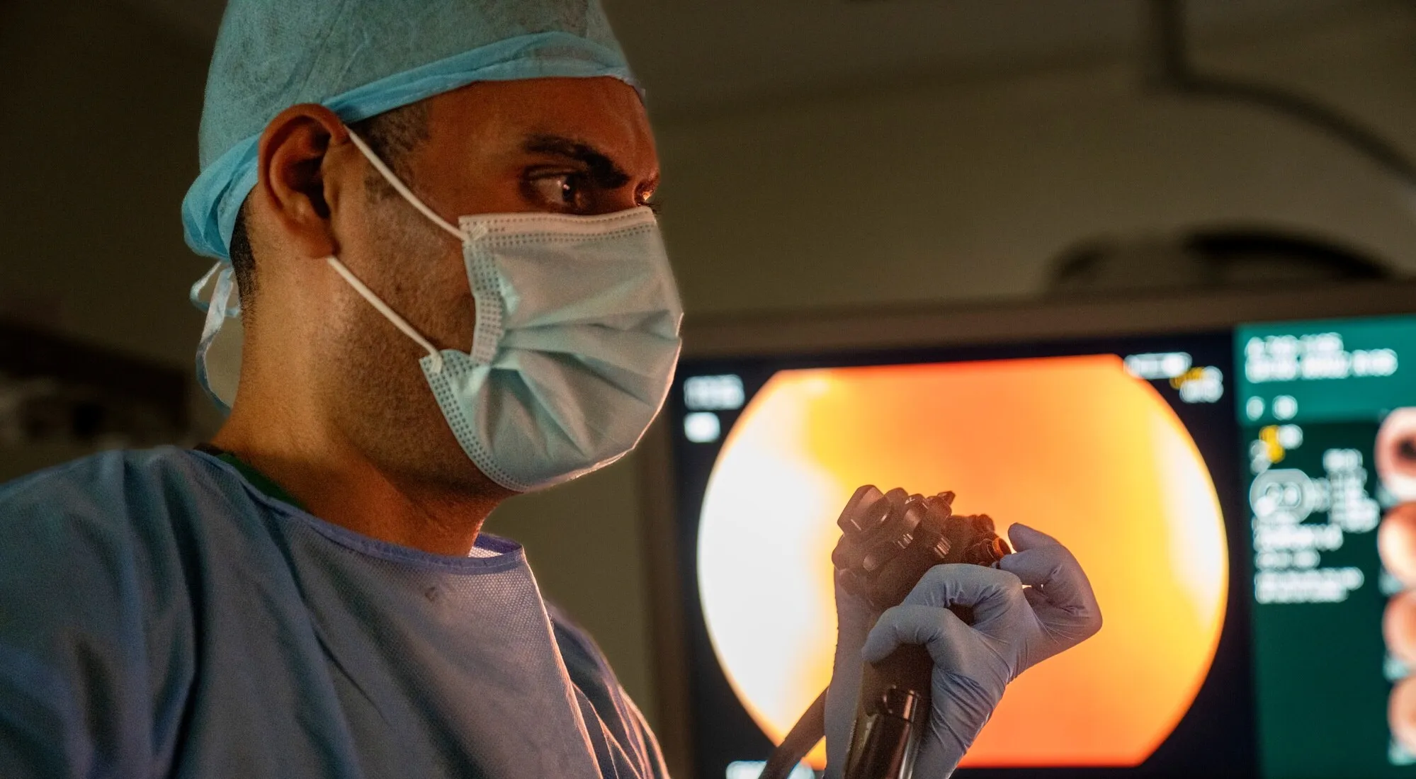 A gastroenterologist operates the control dials of an endoscope during a procedure