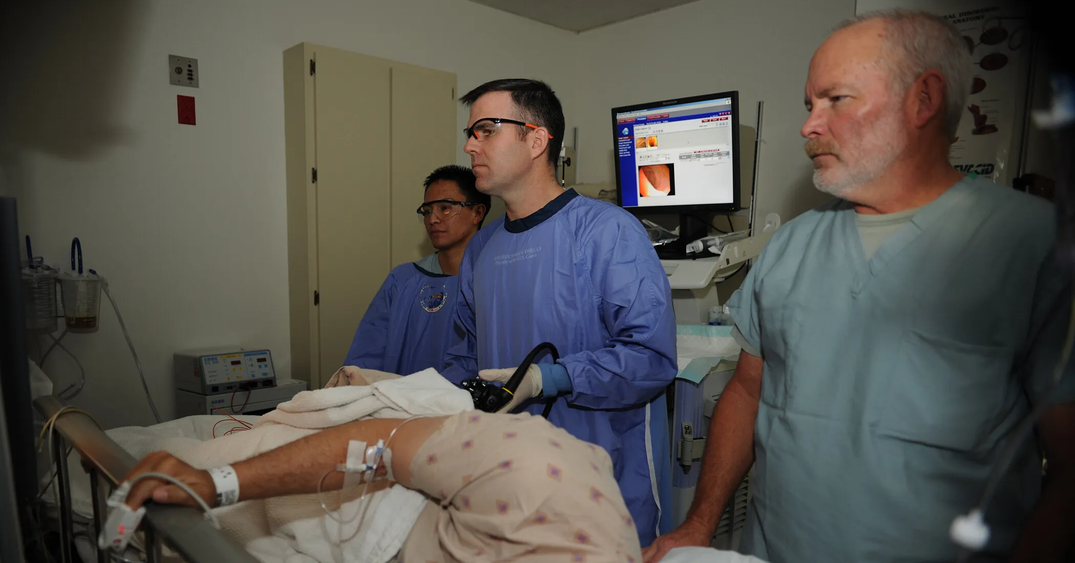 A gastroenterologist and endoscopy team monitor a colonoscopy