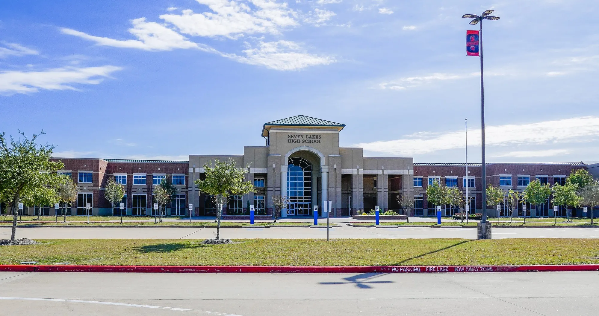 The broad brick facade and main entrance of Seven Lakes High School in Katy