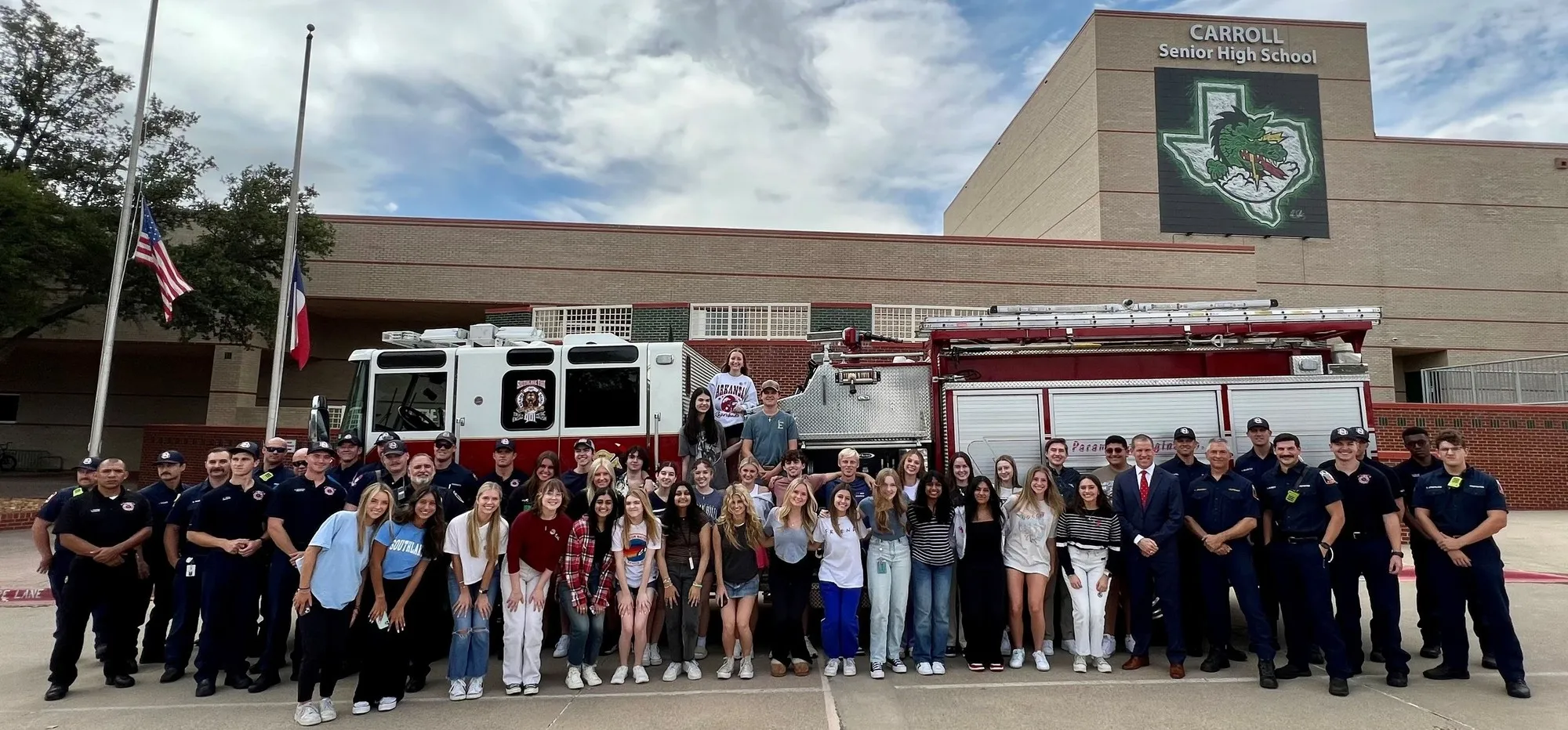 Carroll Senior High School's facade and Dragon signage with students and a fire truck in front