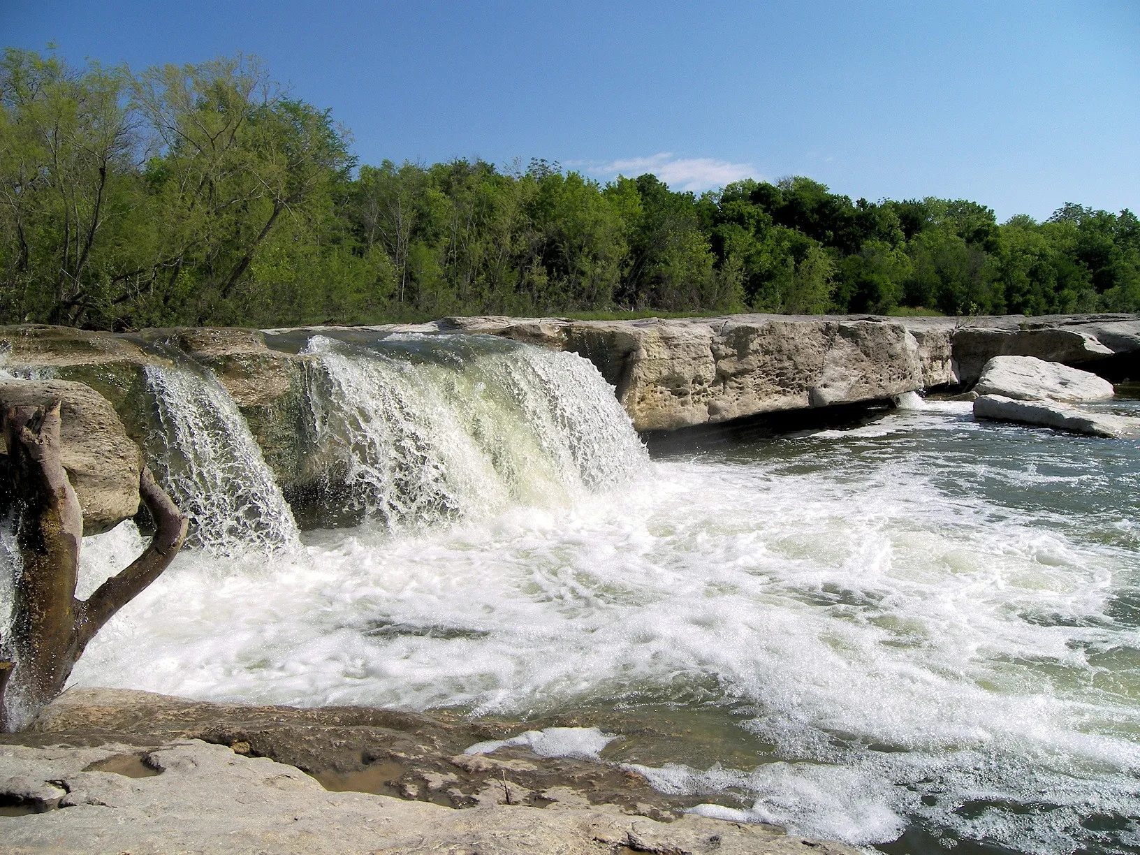 Onion Creek pouring over the broad limestone shelf at Lower McKinney Falls