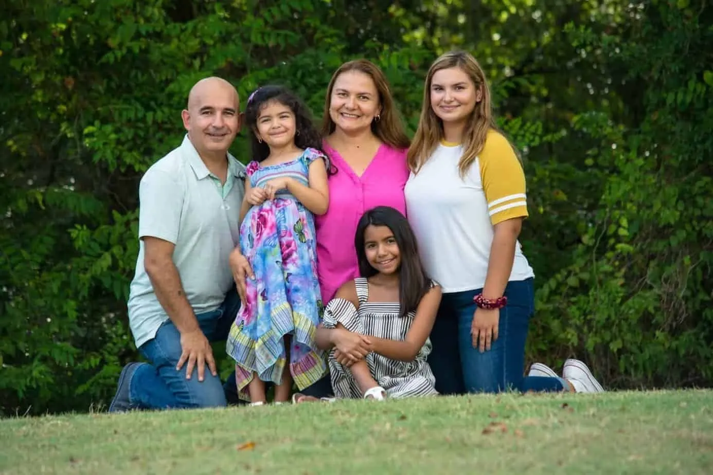 Bee Maids owners Maricela and Jorge posing outdoors with their family