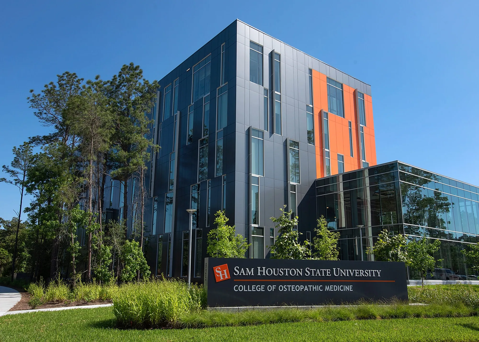 The modern gray and orange Sam Houston State University College of Osteopathic Medicine building in Conroe