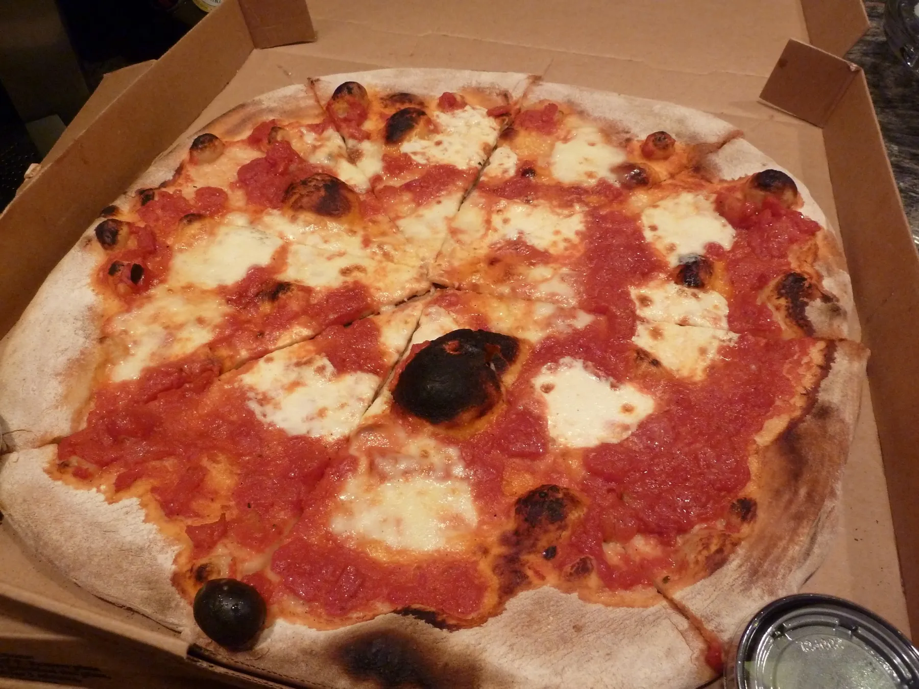 A margherita pizza with fresh mozzarella, tomato and basil