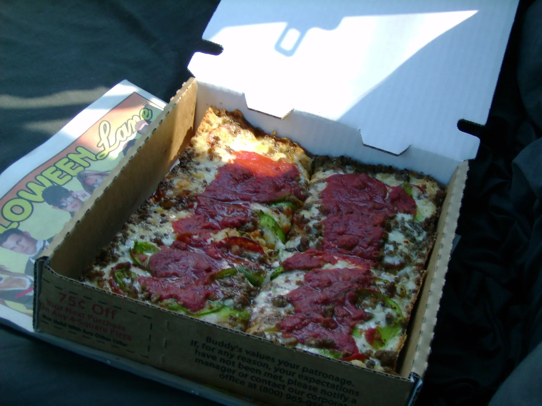 A square of Detroit-style pan pizza with a crisp cheese edge