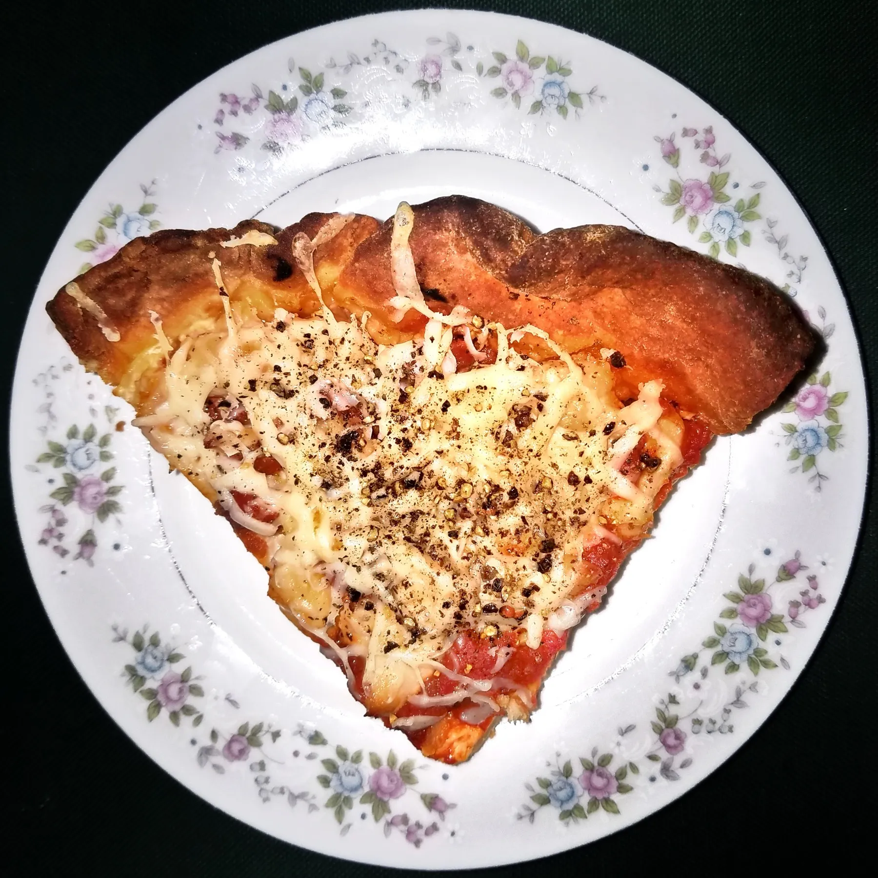 A thick square of pan pizza with cheese to the edge