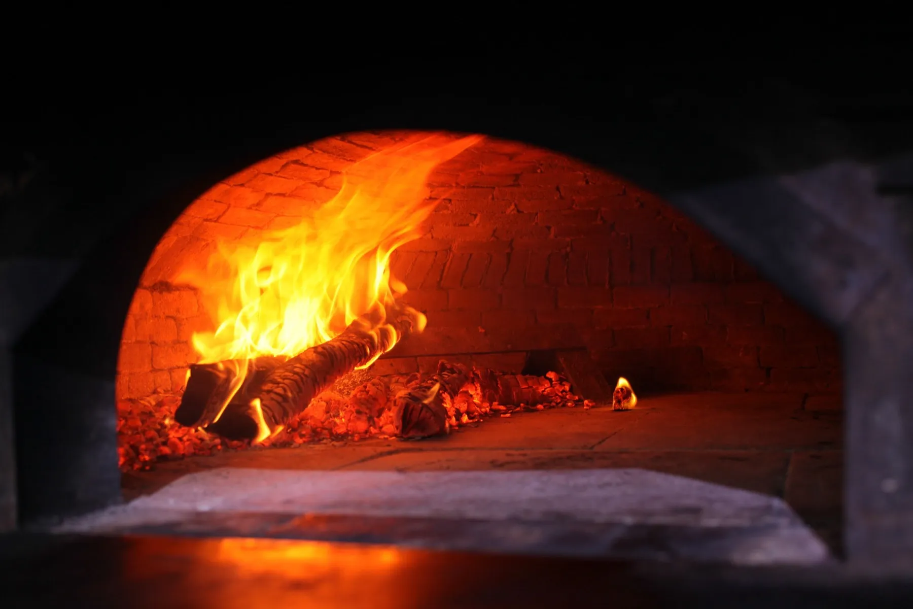 Flames inside a wood-fired brick pizza oven