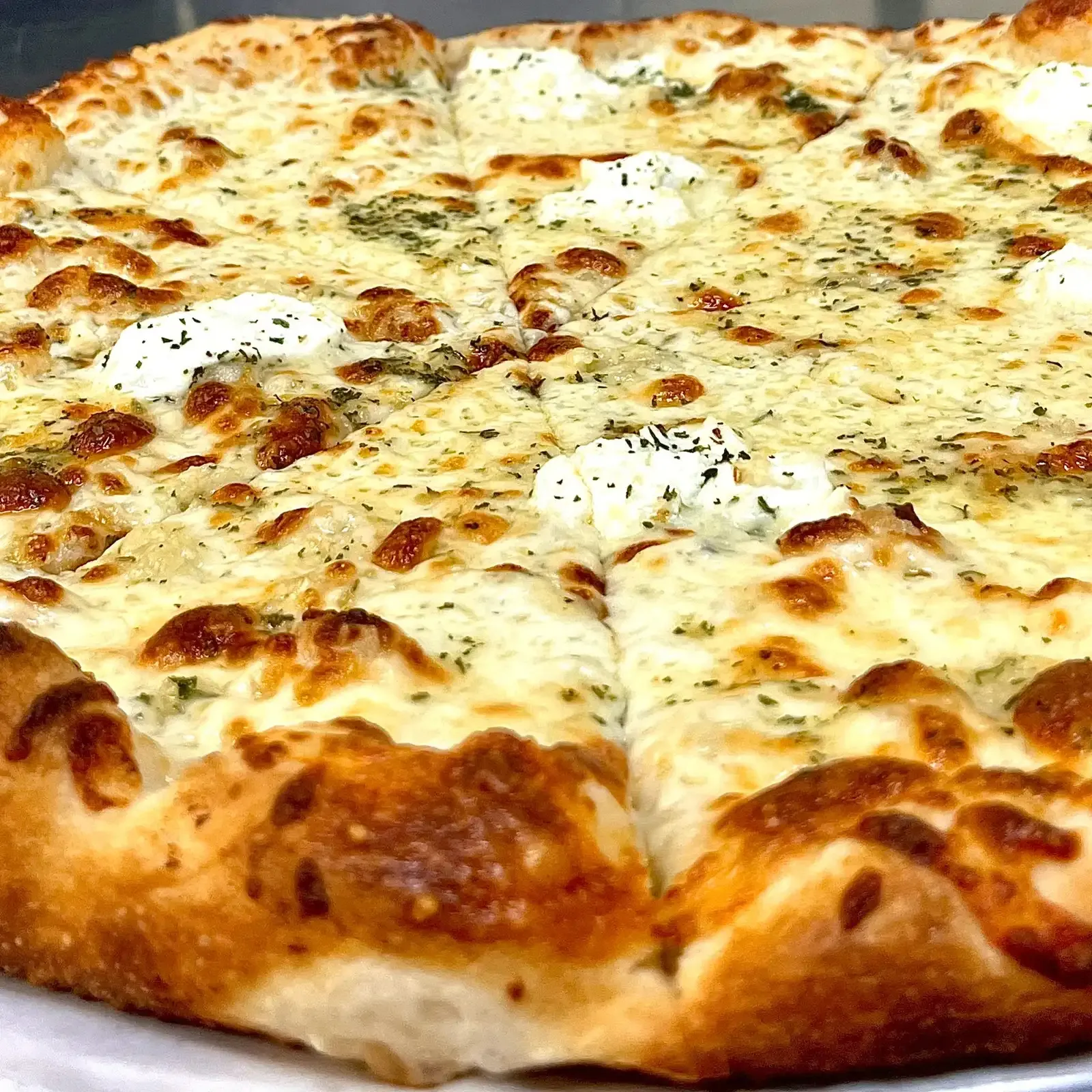 A close view of Capo's white pizza topped with mozzarella, ricotta and herbs
