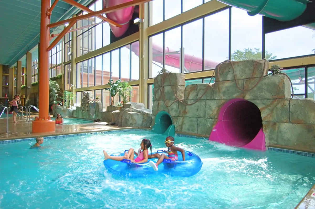 Slides and pools inside a glass-roofed indoor water park