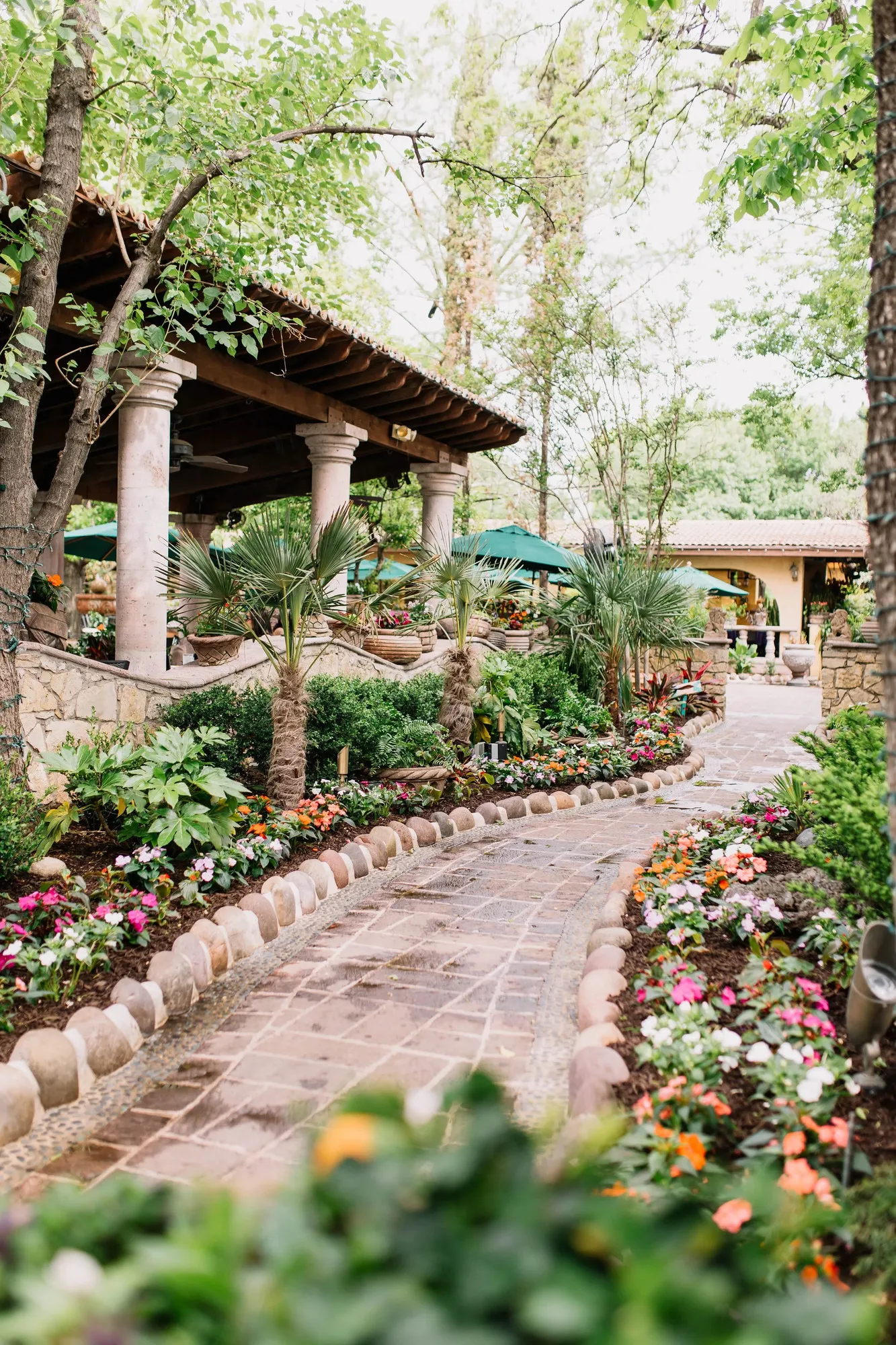 A flower-lined stone path winding between the covered dining areas at Joe T. Garcia's
