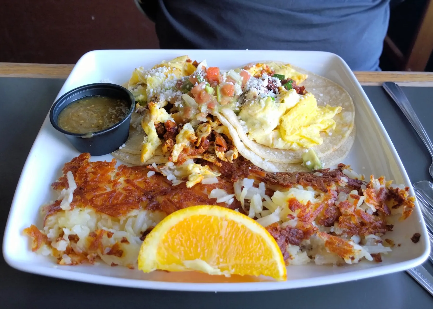 Two breakfast tacos in flour tortillas on a plate