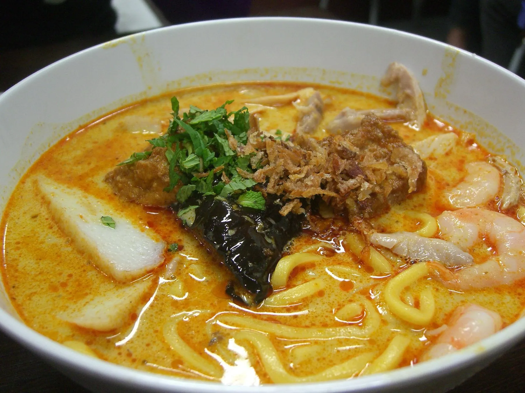 A bowl of curry laksa with noodles