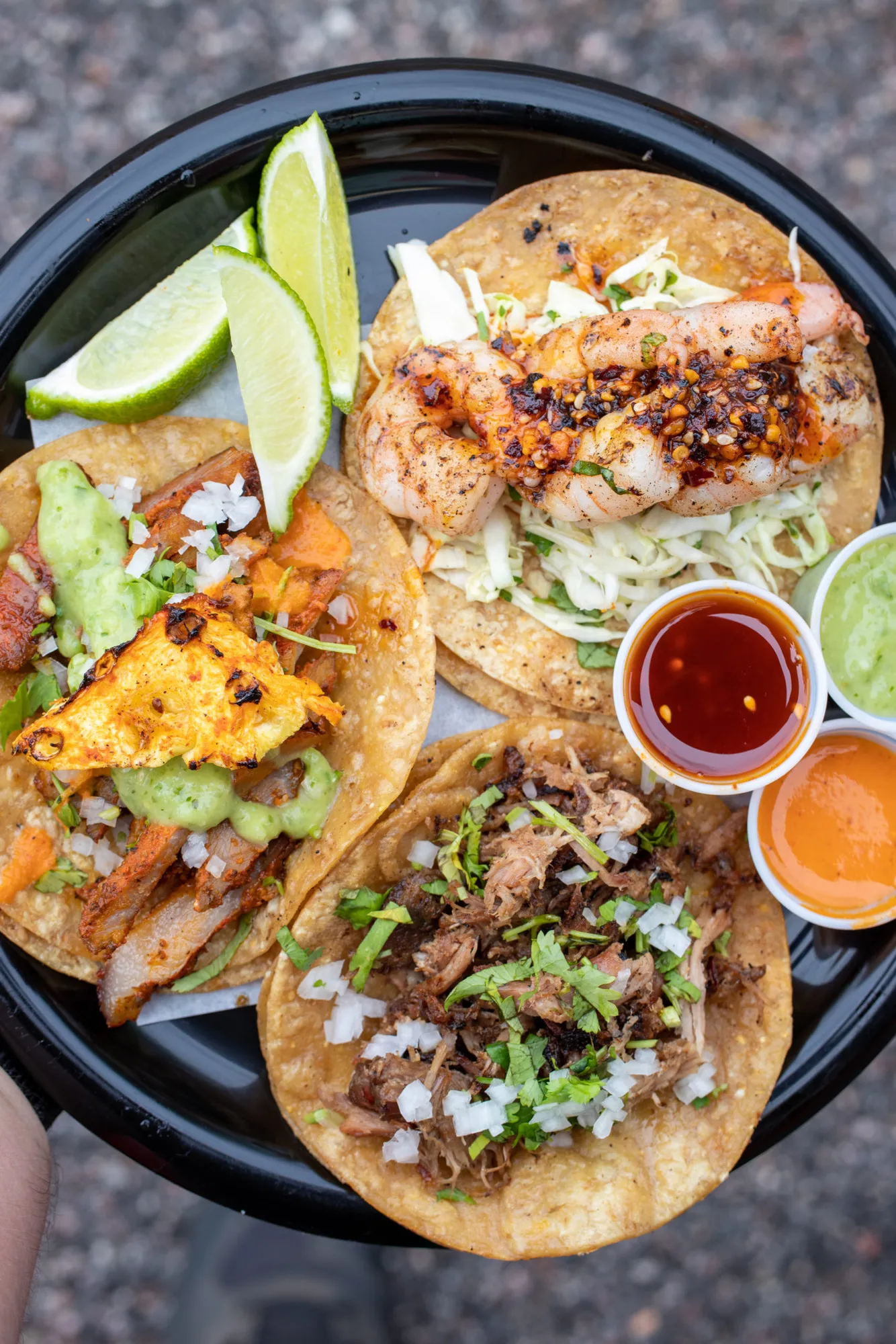 A Paprika ATX plate with tacos, lime wedges and three small cups of salsa