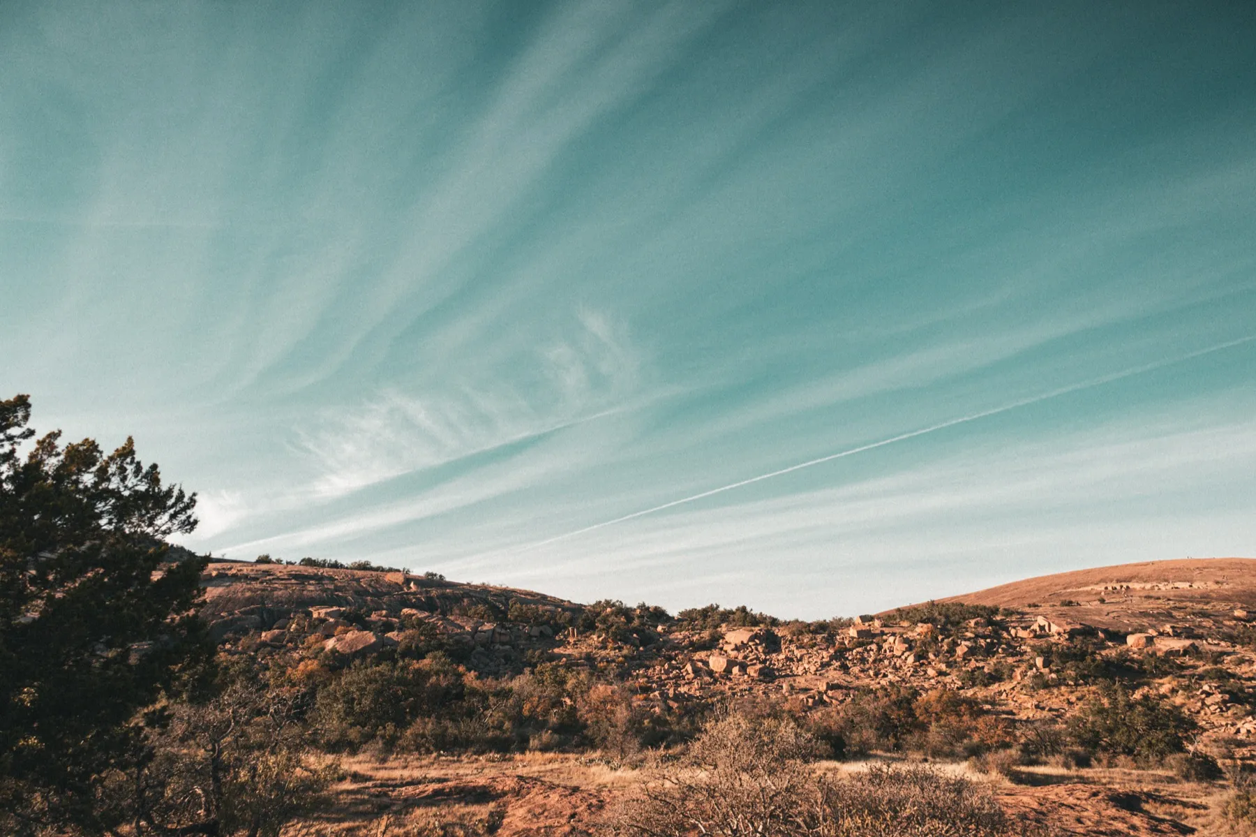 The pink granite summit dome of Enchanted Rock rising above the surrounding scrub