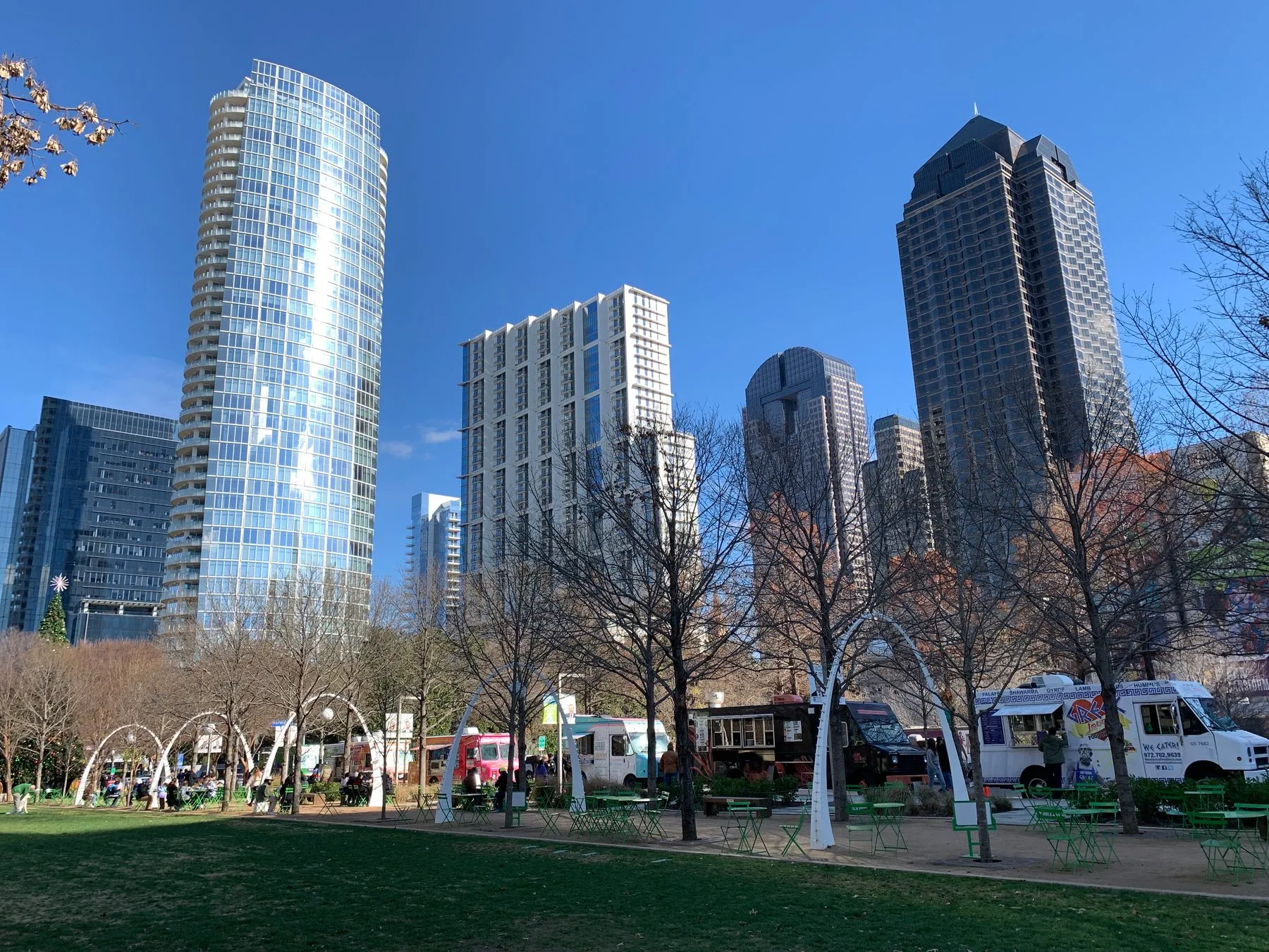 Food trucks and the downtown skyline seen from the lawn at Klyde Warren Park