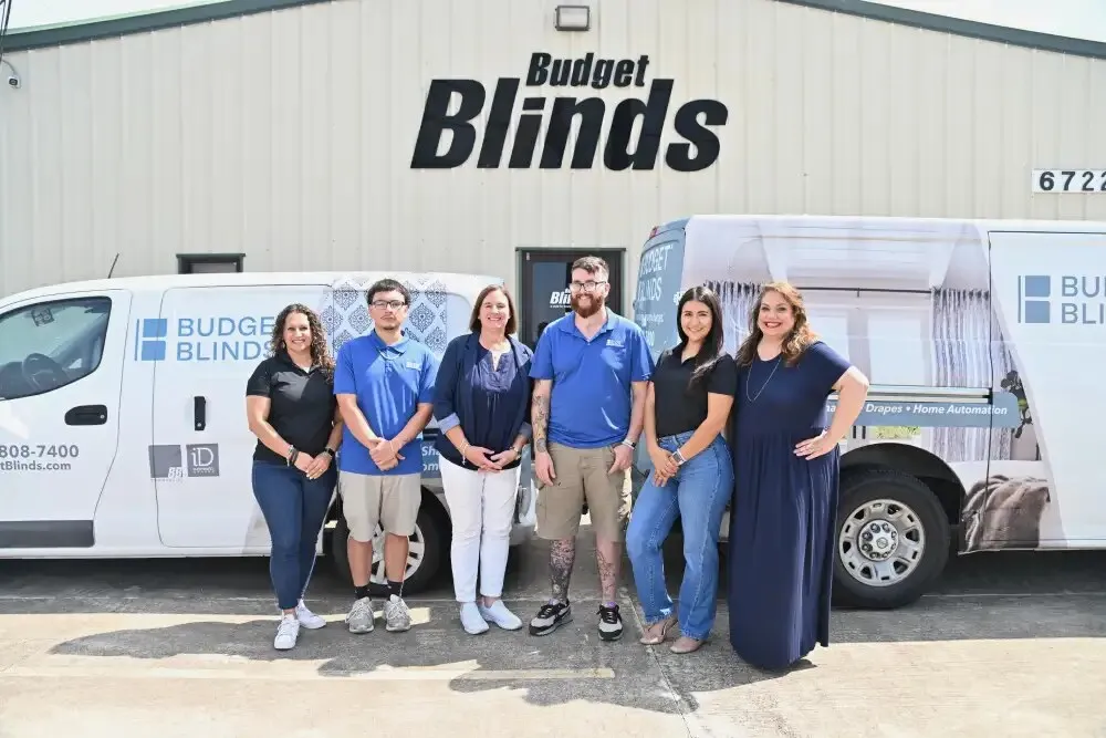 Six Budget Blinds of Greater Corpus Christi team members outside their branded shop and service vans