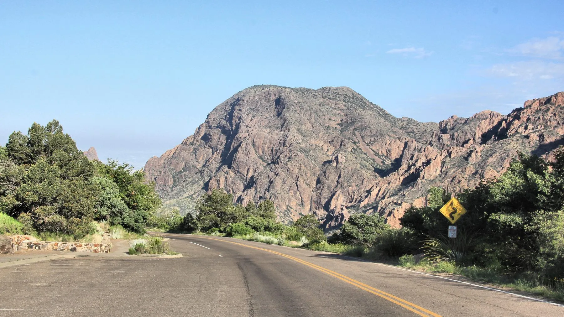 Chisos Basin Road curving past mountain cliffs at the Lost Mine Trailhead