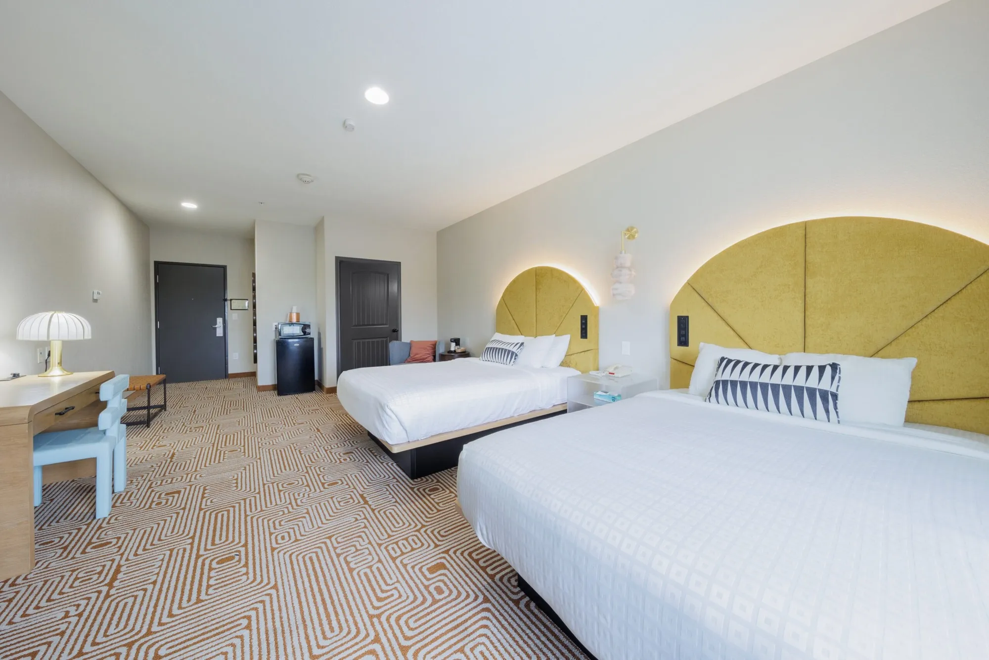 Two beds and yellow headboards in a Blanco River Hotel guest room