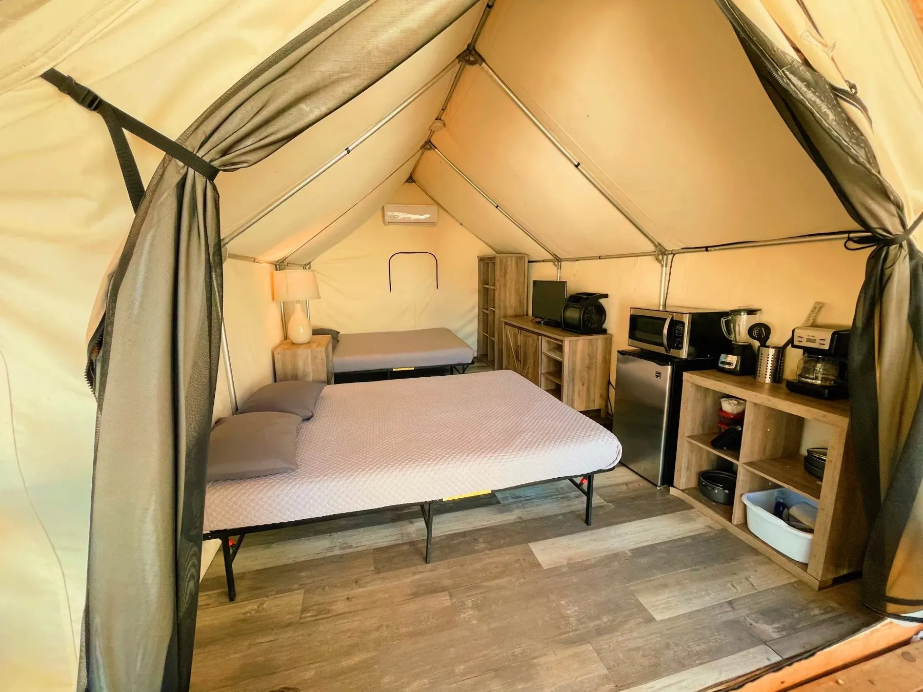 Bed and chair inside a furnished tent at Blue River Camp