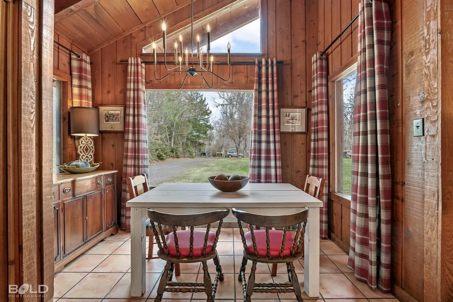 Wooden cabin dining room with red chairs at Caddo Shores
