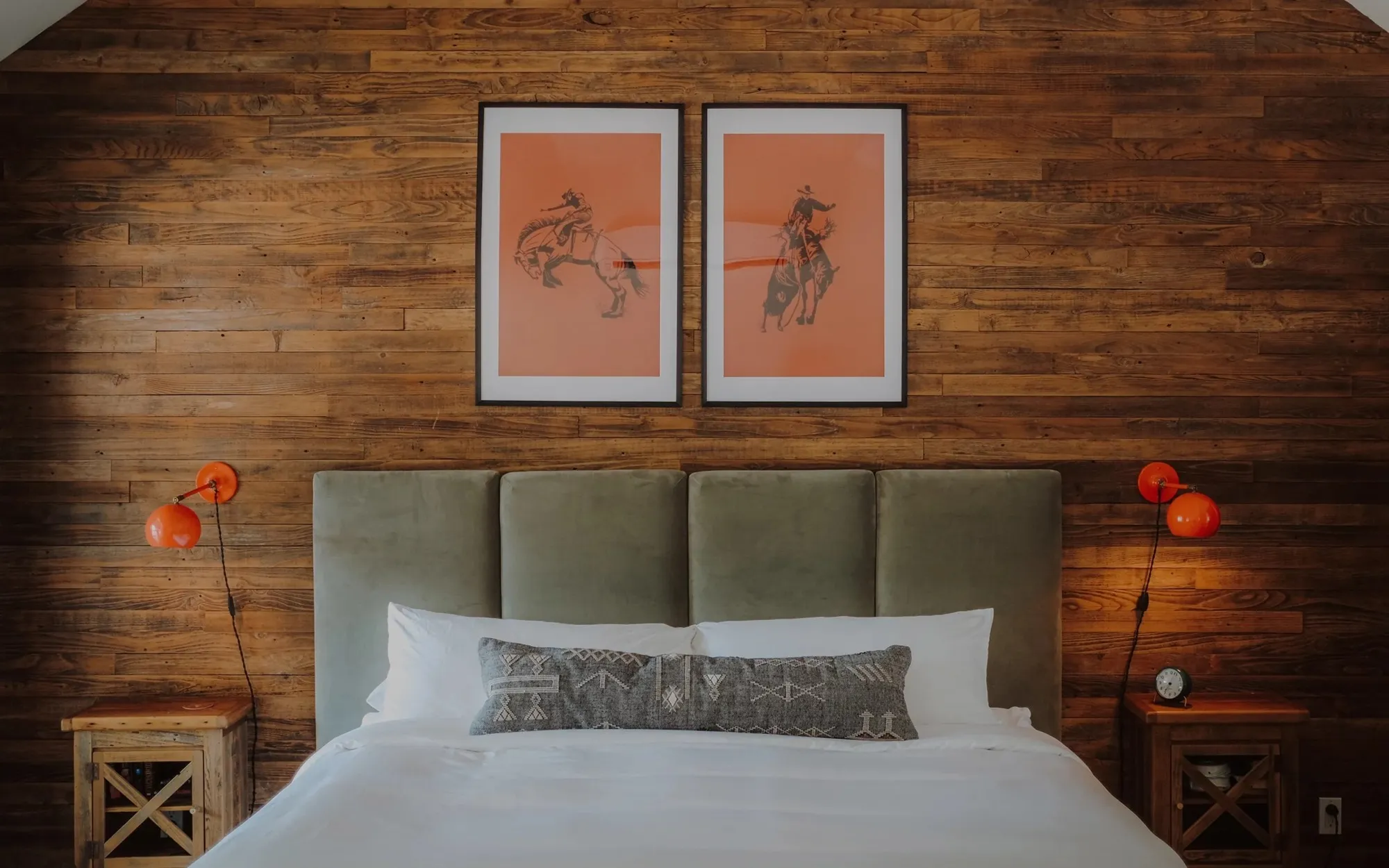 Guest bed against a wood-paneled wall at Camp Comfort