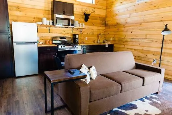 Kitchen and sofa inside a Coyote Clubhouse at Camp Fimfo Texas Hill Country