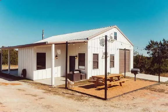 White Sunrise House with a covered porch at Camp Hideaway Fredericksburg