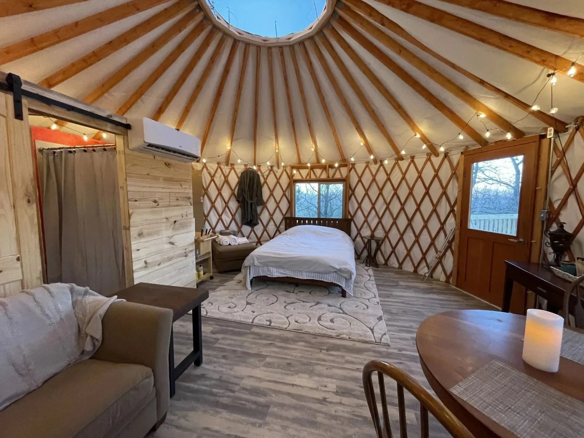 Bed and seating beneath the round roof of a Cross Timbers yurt