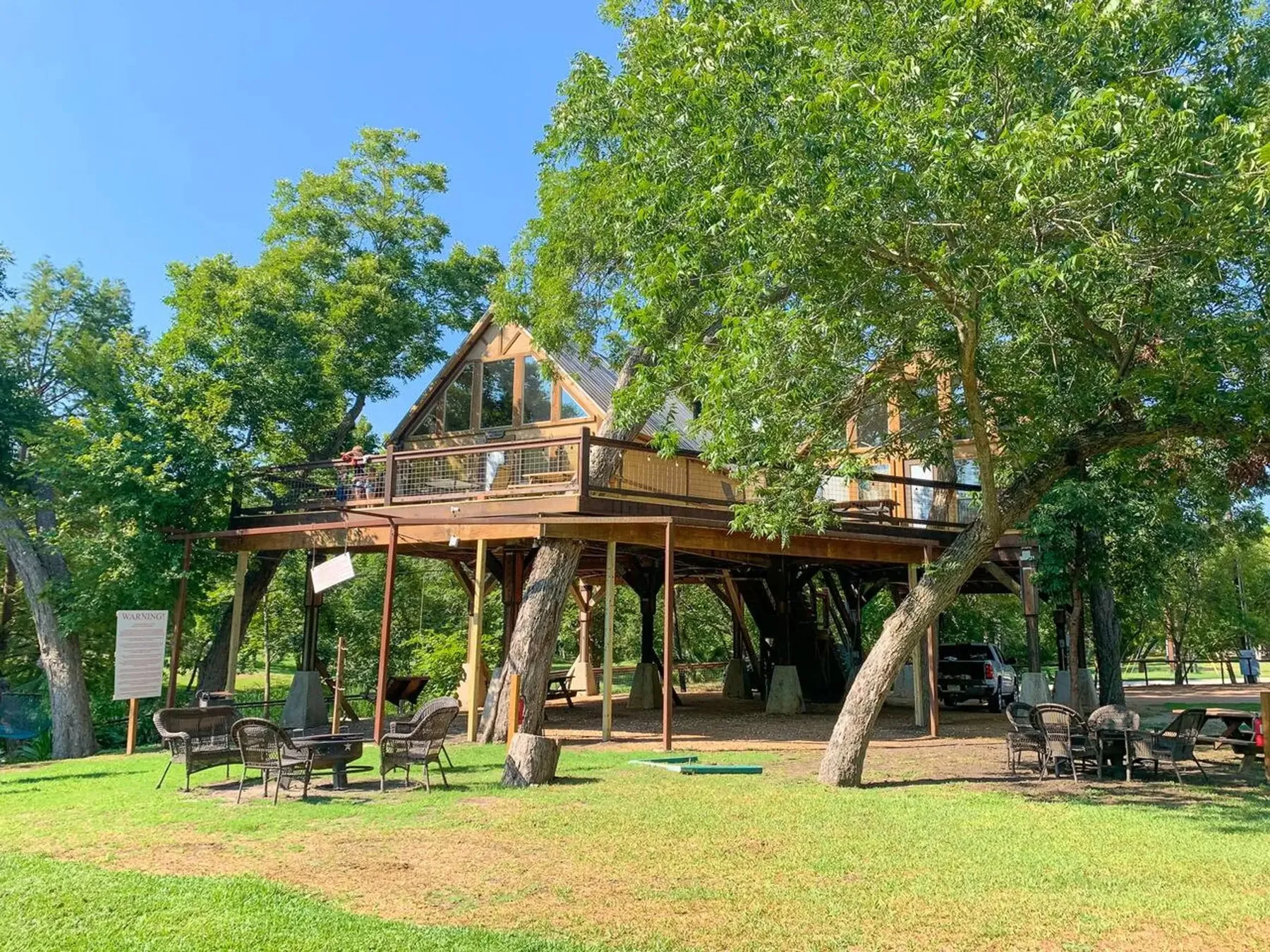 Raised treehouse with a wooden deck at Geronimo Creek Retreat