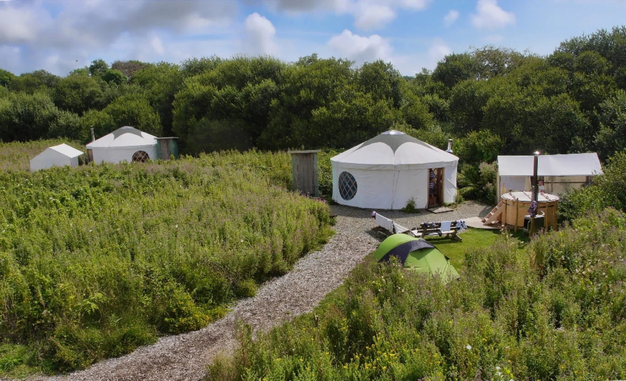 Round glamping tents set on a green field