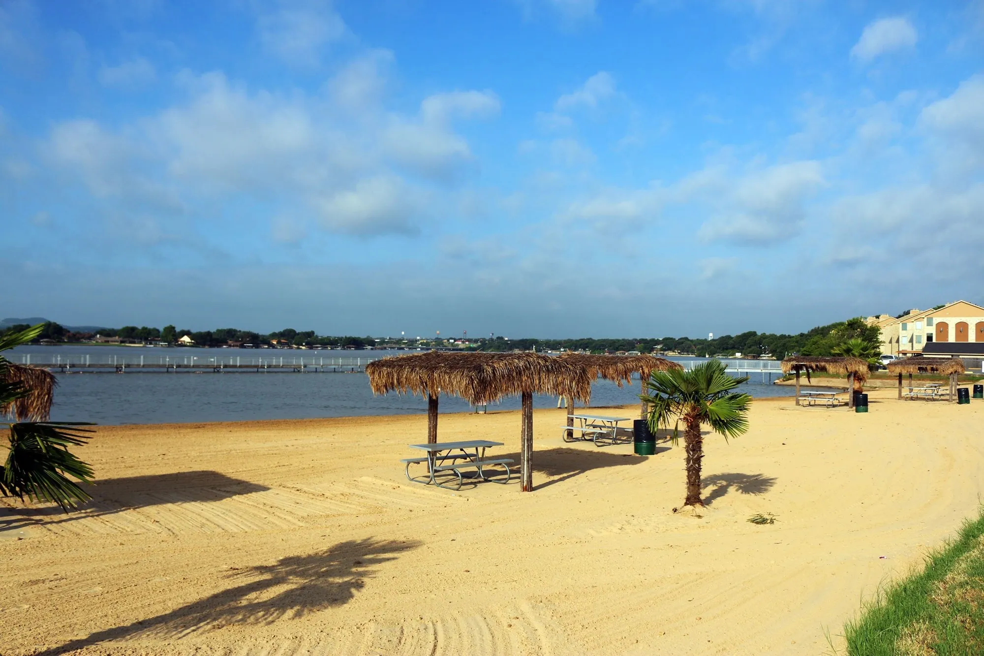 Sand, palm trees and picnic shelters at Granbury City Beach