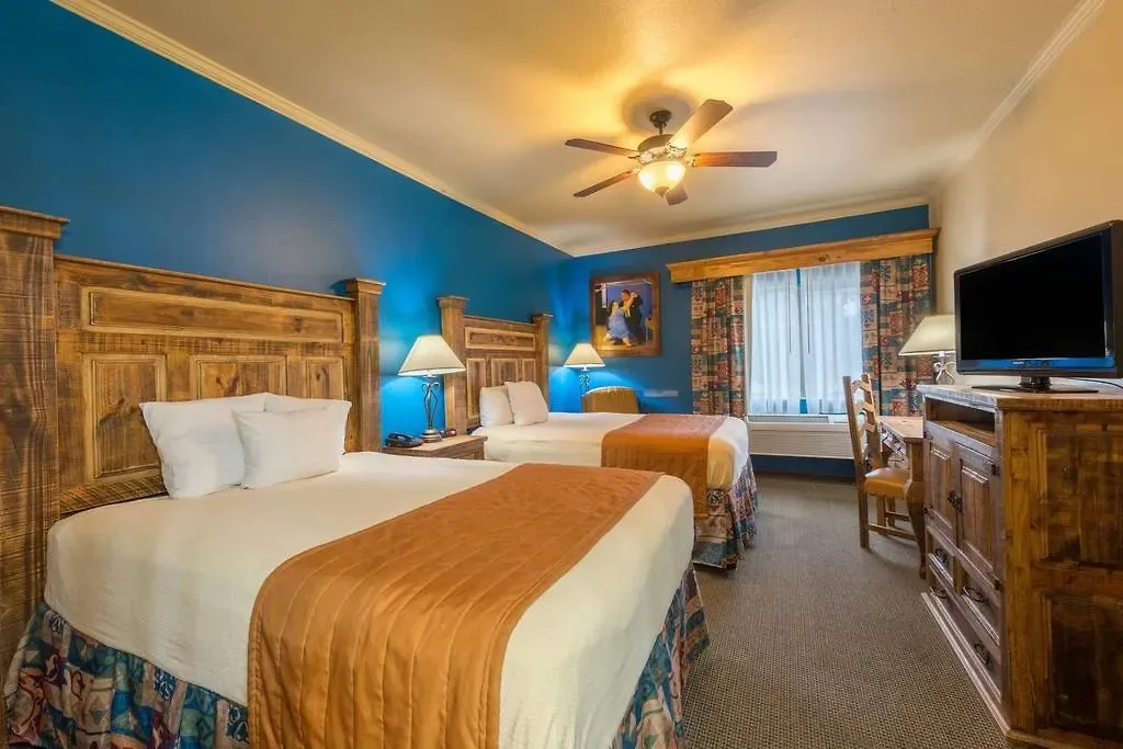 Two beds and rustic wooden furniture in a La Hacienda Inn guest room