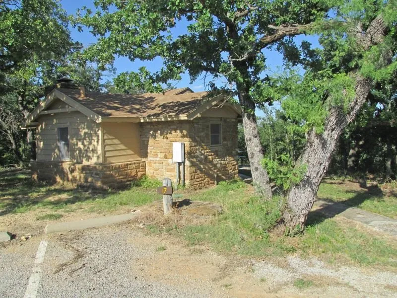 Stone cabin beside a tree at Lake Brownwood State Park