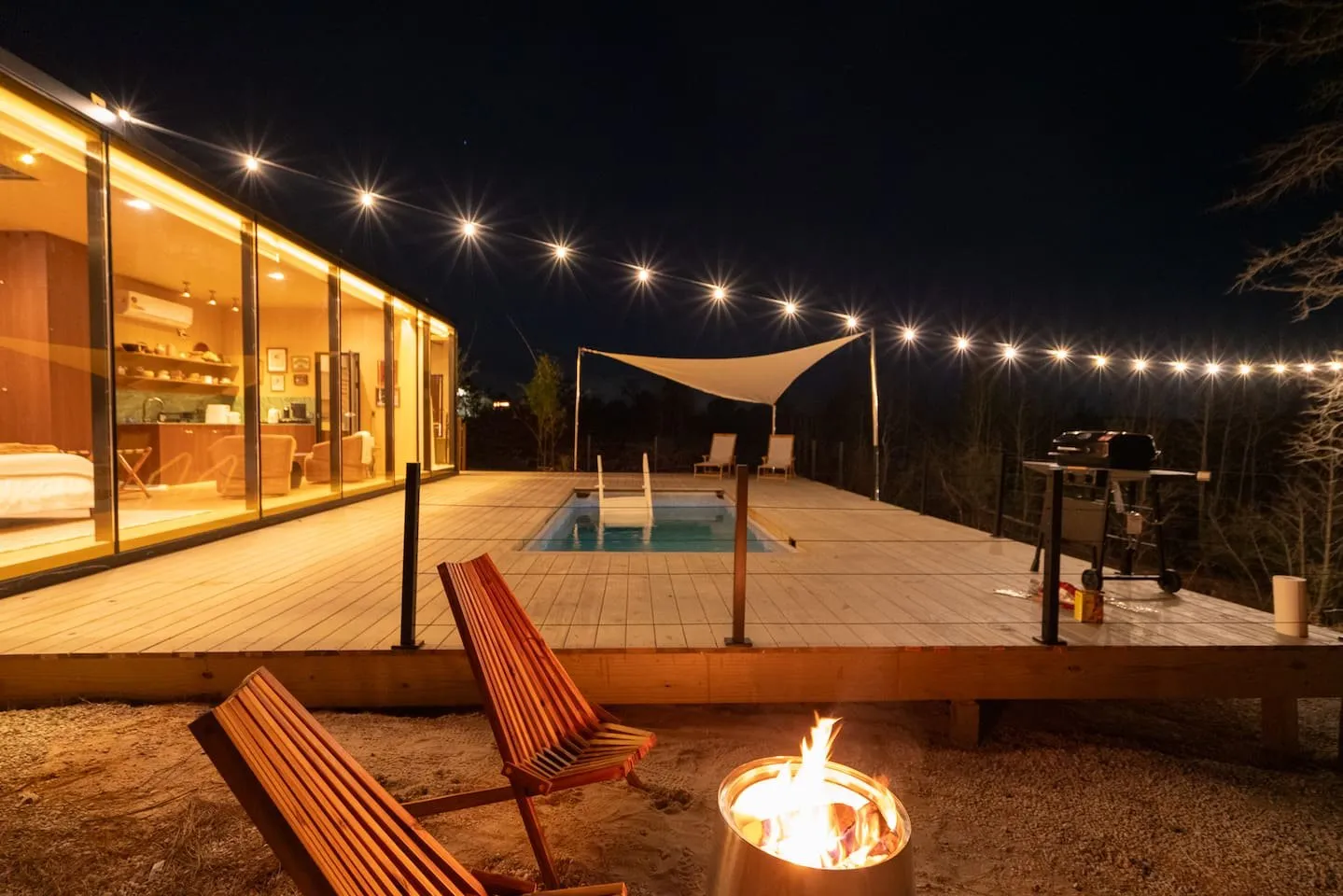 Sol cabin's pool and deck lit at night at Luminary