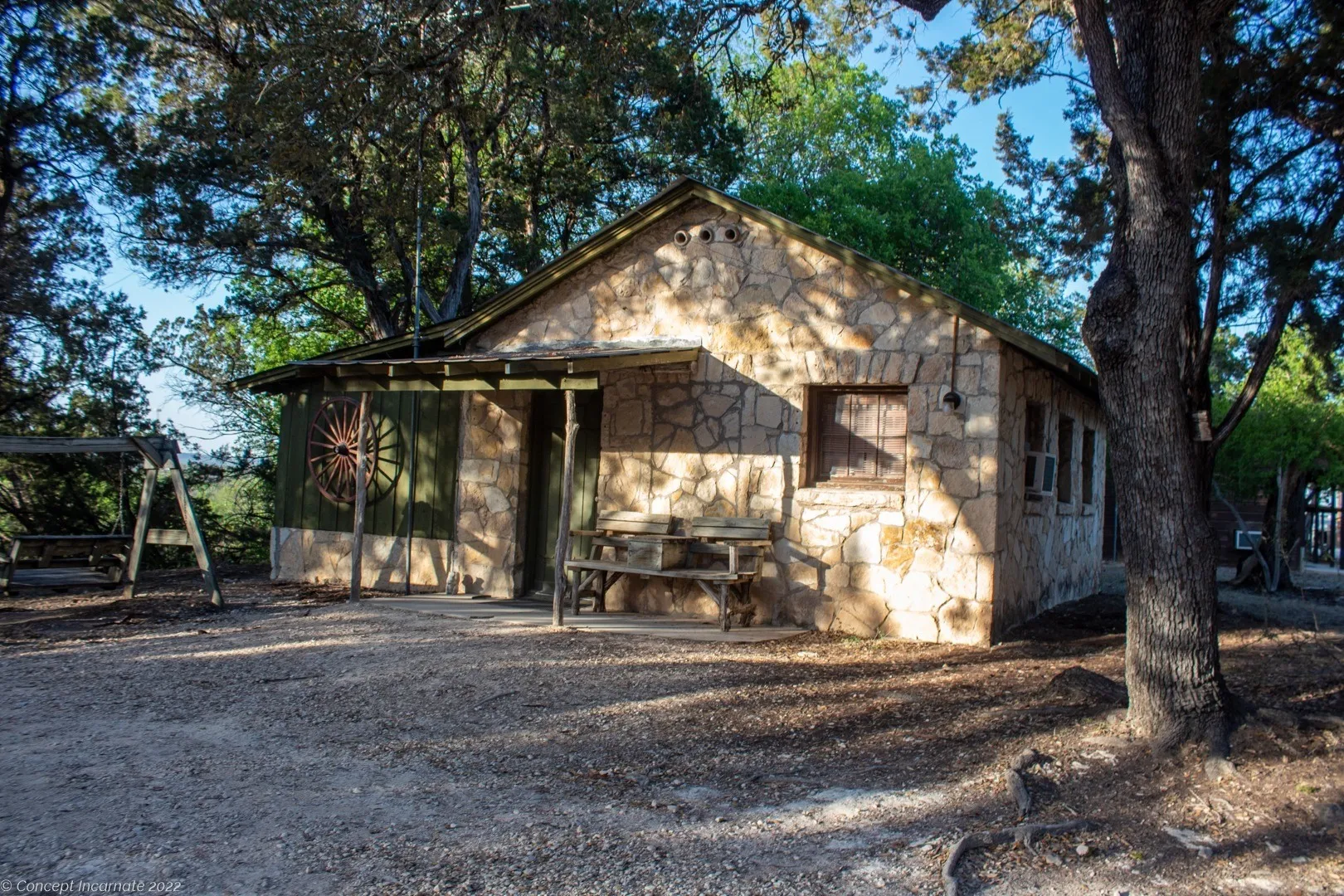 Stone cabin shaded by trees at Mayan Dude Ranch