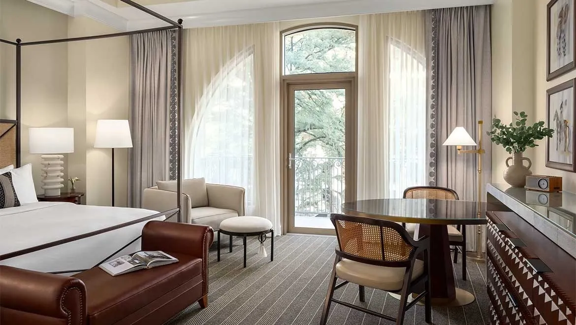 Mokara guest room with a bed, sitting area and arched balcony doorway