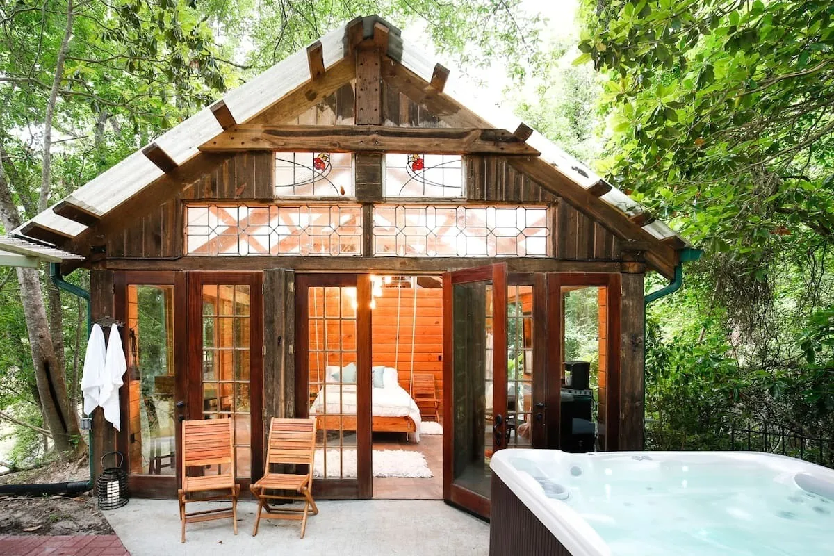 Wooden cabin with a deck and outdoor hot tub at Naturalist Boudoir