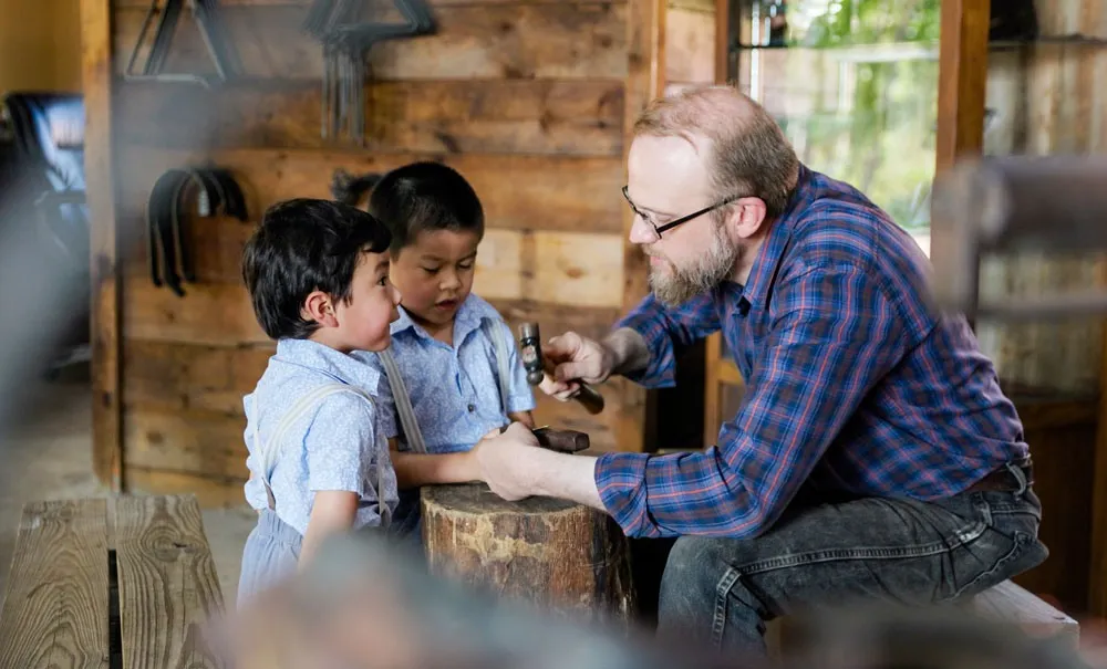 A child learning to shape clay at Homestead Heritage