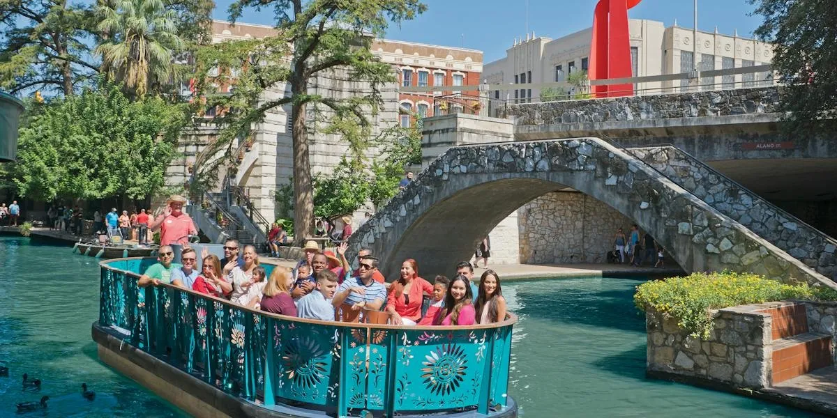 A GO RIO sightseeing boat passing under a stone bridge