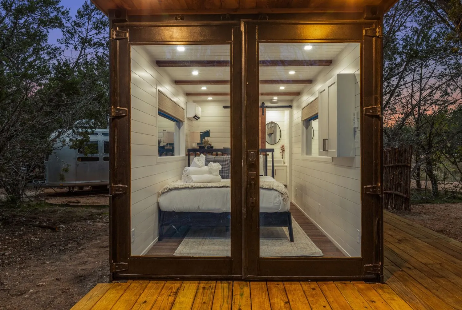 Glass-front cabin with a bed visible inside at Onera Fredericksburg