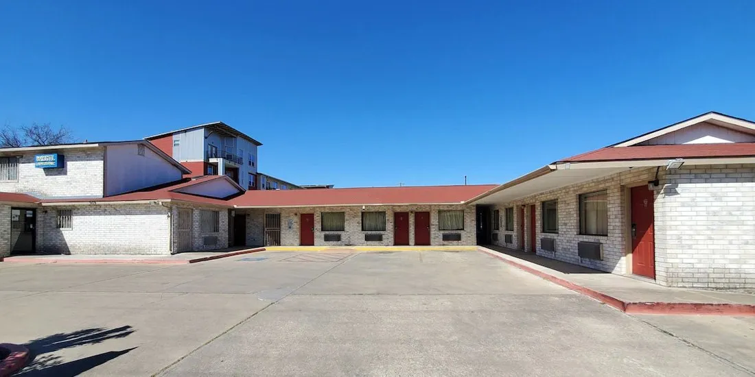 Parking courtyard and ground-floor rooms at River Inn Motel in San Antonio