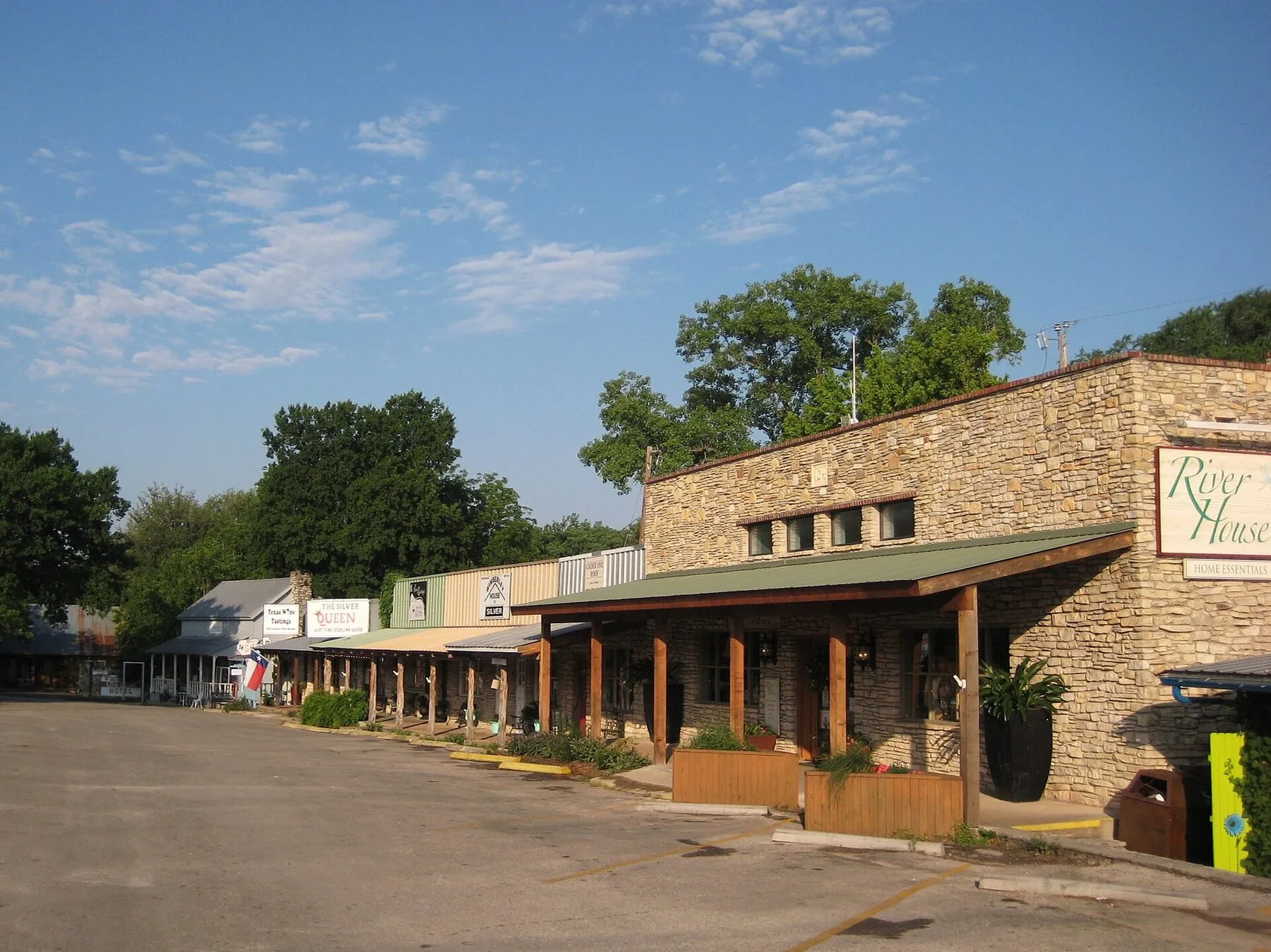 A stone storefront and leafy trees in central Wimberley